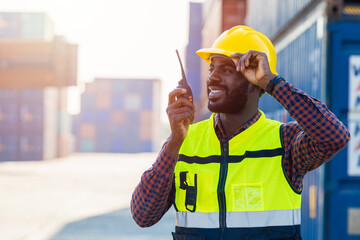 black worker African working engineer foreman radio control in port cargo shipping customs...