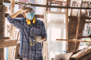 tired stress elderly asian man worker work in builder wood workshop making furniture