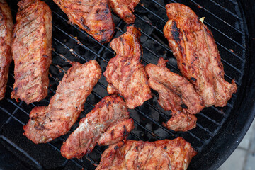 Pork neck getting grilled outdoors