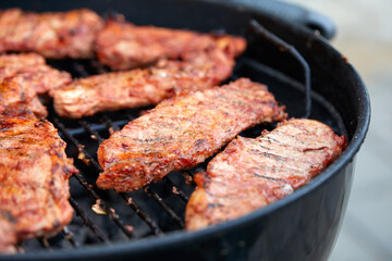 Pork neck getting grilled outdoors