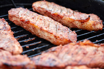 Pork neck getting grilled outdoors