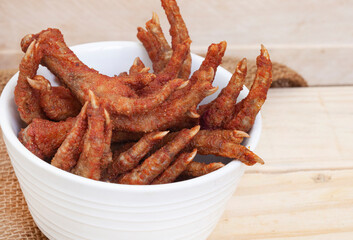 South African township delicacy,  fried chicken feet or walkie talkies in a white bowl with rustic...