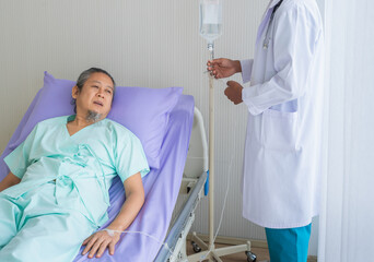 Obraz premium Elderly patient man unhappy, suffer, sadness from sick looking to outside window and doctor with stethoscope adjust saline. Doctor or nurse take care senior patient health admission at hospital