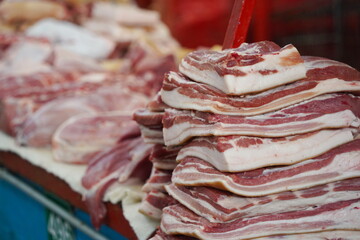 Almaty, Kazakhstan - 03.25.2022 : Pork slices are laid out in a row for sale in a hypermarket.