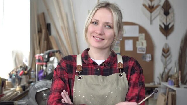 Portrait of a creative woman in a carpentry or art workshop. A woman is an artist or carpenter