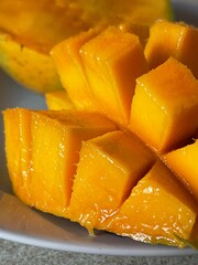 Vertical close up of a juicy ripe mango fruit cut in cubes
