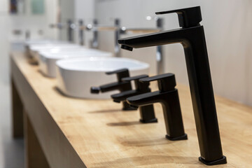Samples of faucets for bathroom and kitchen in the store. A variety of modern models. Construction...