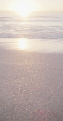 Vertical image of sea with waves and blue sky on sunny beach