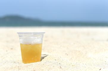 Cold vietnamese beer in cup with ice on white sand beach of Nha Trang Vietnam