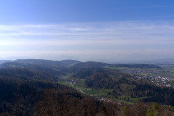 Fototapeta na wymiar Aerial view over rural landscape with Swiss Alps in the background seen from local mountain Uetliberg on a blue cloudy spring day. Photo taken April 21st, 2022, Zurich, Switzerland.
