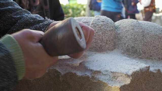Closeup of medieval stonemason hands sculpting stone af Arribada festival