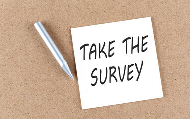 TAKE THE SURVEY text on sticky note on a cork board with pencil ,