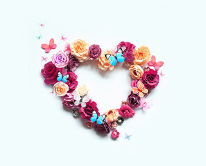 Happy mothers and Valentines day. Bouquet of colorful assorted roses in heart shape and butterfly on white background.
