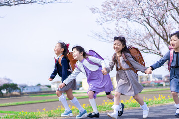 Fototapeta na wymiar ランドセルを背負って楽しく登校する小学生の女の子たち