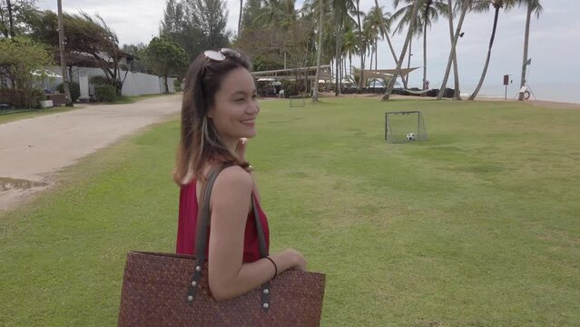 Young asian woman wear red dress and walking relaxing on the beach at summer vacation holidays in slowmotion