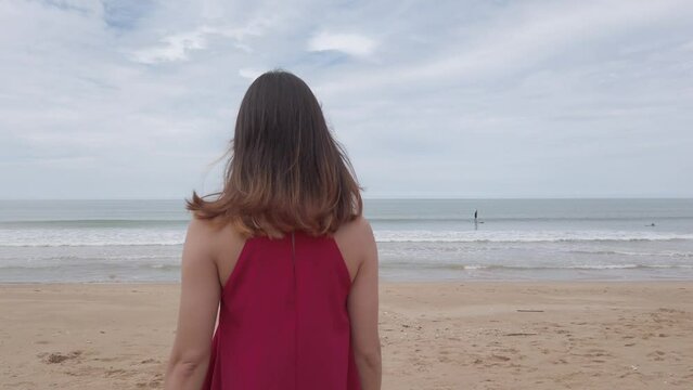 Young asian woman wear red dress and walking relaxing on the beach at summer vacation holidays in slowmotion