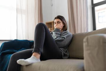 Obraz premium mental health, psychological problem and depression concept - stressed woman sitting on sofa at home