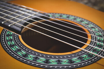 Classical guitar close up. Acoustic guitar background, strings, frets, pegs.