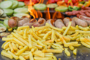 Fried vegetables with sausages and french fries