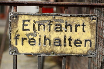 Altes, rostiges Schild Einfahrt freihalten an einem Zaun - obrazy, fototapety, plakaty