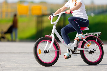 Obraz na płótnie Canvas Little girl on a bicycle in summer park.