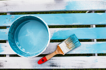 Can of turquoise paint with brush