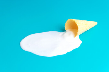 Waffle cone ice cream puddle on blue