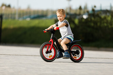 little boy riding a bike in a city park
