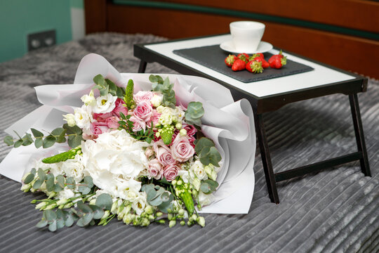 Morning coffee and flowers on bed. Breakfast in bed