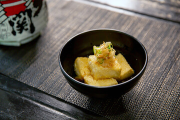 tempura, Agedashi fried tofu in the traditional Japanese ramen restaurant, with a black bowl on a...