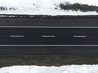 Aerial view of a road with one lane and snow in winter