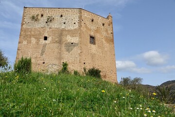 Fototapeta na wymiar View of the Ulloa tower in the Granada town of Vélez de Benaudalla (Spain) on a sunny spring morning