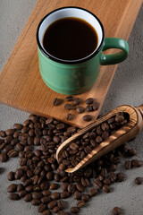 Green cup of coffee with coffee beans	