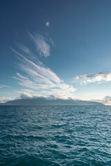 Bright blue ocean in a cloudy blue sky, with islands on the horizon in albania