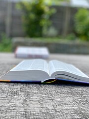 Bible flat lay outdoor. Open Bibel on a wooden table. Baselland, Switzerland - 26.05.2022