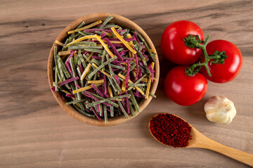 Traditional Turkish colorful noodles with tomato, garlic and pepper on wooden background