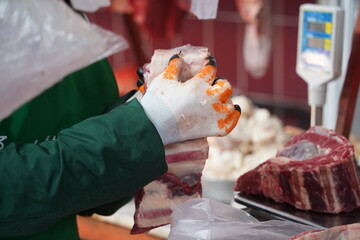 Almaty, Kazakhstan - 03.25.2022 : Cutting different parts of meat for sale in an open market.