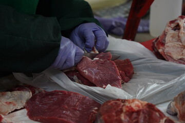 Almaty, Kazakhstan - 03.25.2022 : Cutting different parts of meat for sale in an open market.