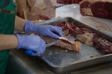 Almaty, Kazakhstan - 03.25.2022 : Cutting different parts of meat for sale in an open market.