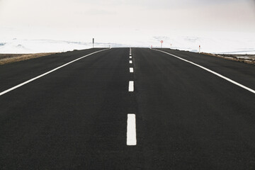 Close up View of an emtpy asphalt road with lanes and snow in winter