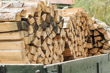Firewood Stacks on car. Heap Firewood Delivery.Firewood for the winter. 