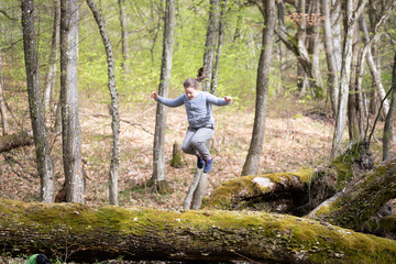 Naklejka na ściany i meble Girl jumping in the woods