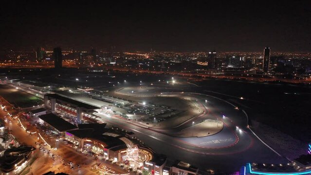 Aerial view of full Dubai Autodrome race track, endurance racing during night endurance competition, Dubai skyline