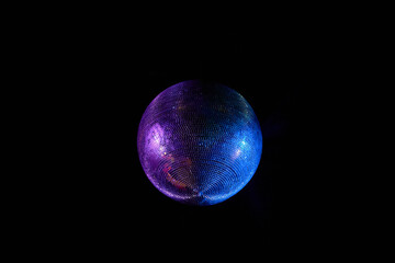 Nightlife and party concept. Purple and blue disco ball hanging from ceiling over black background