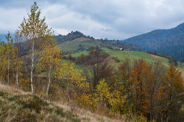 Cloudy and foggy day autumn mountains scene. Peaceful picturesque traveling, seasonal, nature and countryside beauty concept scene. Carpathian Mountains, Ukraine.