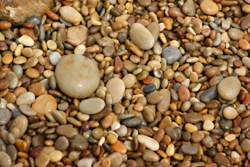 It is a stone that has been cut into a round pebble shape as the rock has been broken and eroded by...