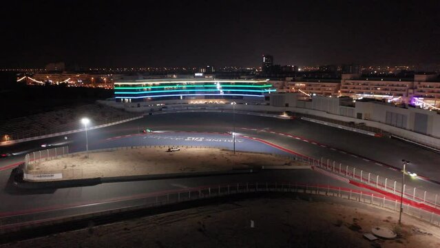 Aerial view of car racing in corner, Dubai Autodrome race track during night endurance competition