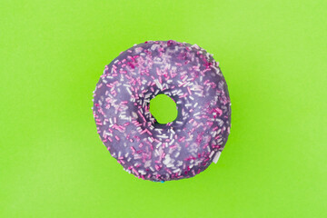 Purple glazed donut on a green background