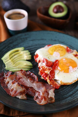 Breakfast with fried eggs with tomato, bacon and avocado