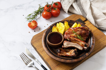 BBQ grilled veal calf brisket meat and french fries potatoes with sauce on a marble tabletop. Copy space.